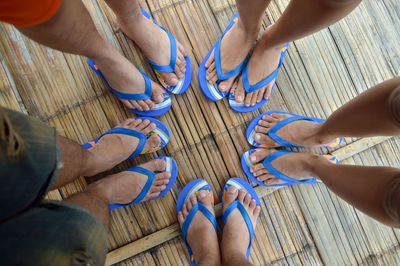 Low section of people standing on wood