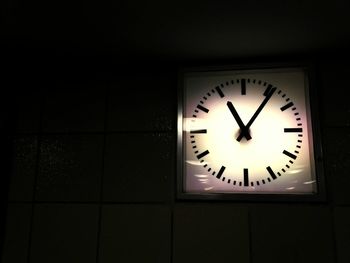 Illuminated clock on wall at night