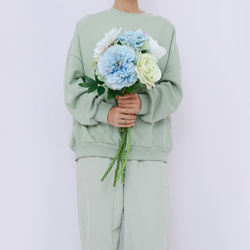 Midsection of woman holding bouquet against white background