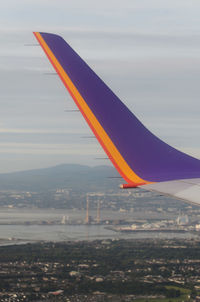 Airplane flying over landscape against blue sky