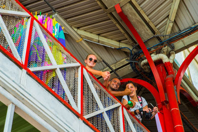 Full length of a smiling young woman standing on railing