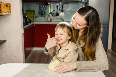 Mother and son preparing food on table