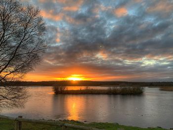 Scenic view of lake against orange sky