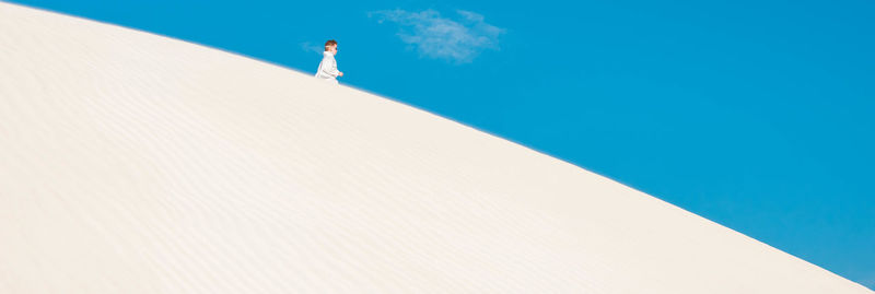 Low angle view of man swimming in pool against blue sky