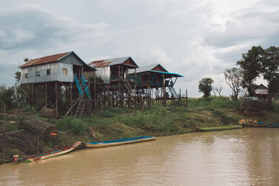 Houses by lake against sky