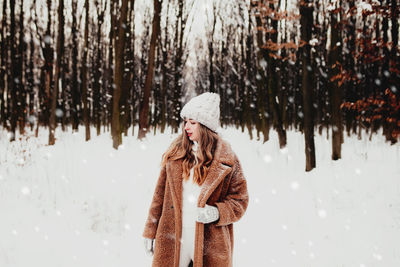 Rear view of woman standing in forest