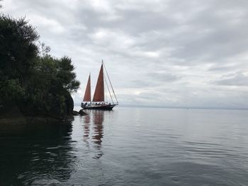 Sailboat sailing on sea against sky