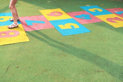 Low section of a girl playing hopscotch