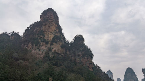 Low angle view of rock formation against cloudy sky