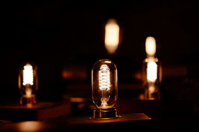 Close-up of illuminated light bulb on table