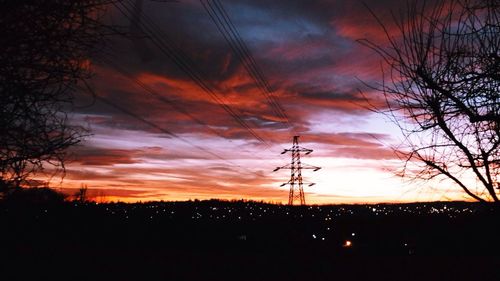 Silhouette of power lines against cloudy sky