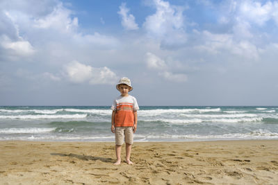 Man standing on beach by sea against sky