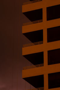 Low angle view of orange building against sky at night