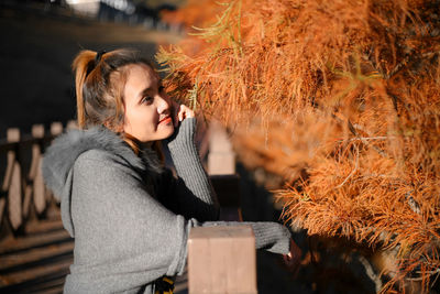 Side view of young woman looking away in park during winter