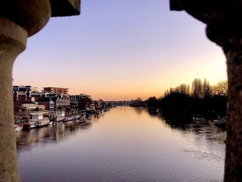 Scenic view of river by buildings against clear sky