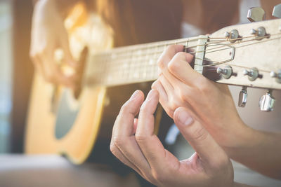 Close-up of couple playing guitar