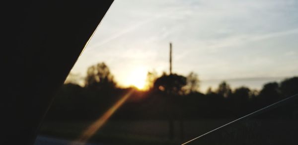 Close-up of silhouette car on road at sunset