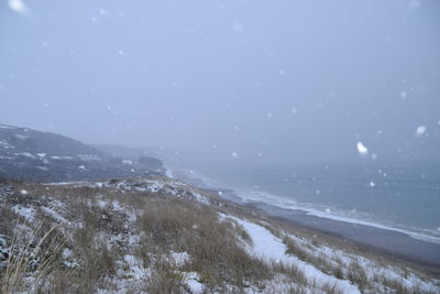 Scenic view of beach against sky during winter