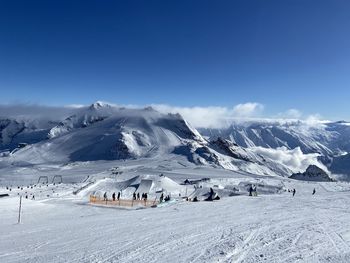 Scenic view of snowcapped mountains against blue sky