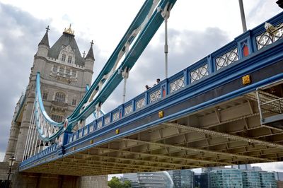 Low angle view of bridge and buildings against sky