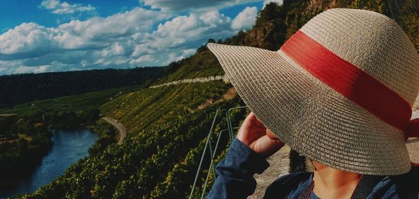 Cropped image of hand with hat on land