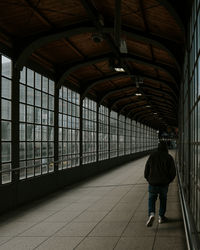 Rear view of man walking on railroad station