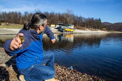 Man throwing a rock in lake