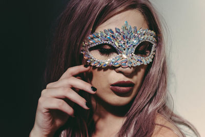 Portrait of woman wearing mask against white background