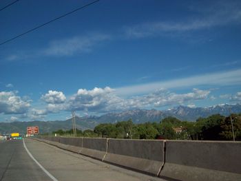 Railroad tracks by road against sky