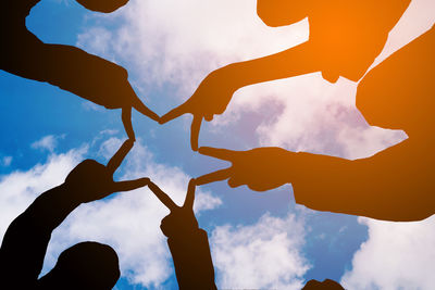 Low angle view of silhouette hand against sky