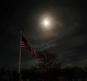 Low angle view of flag against sky at night