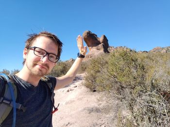 Portrait of smiling young man against sky