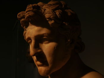 Close-up portrait of statue against black background