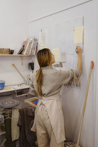 Potter preparing checklist while standing at workshop