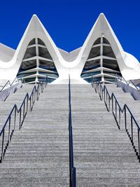 Low angle view of steps leading towards building against clear blue sky