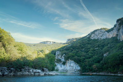 Scenic view of river amidst mountains against sky