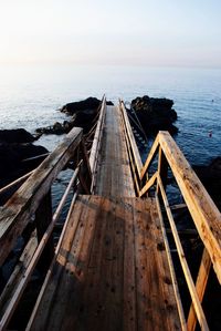 Scenic view of sea with long wooden pier over lava rocks