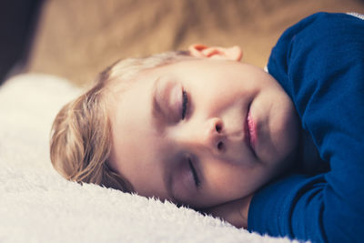 Close-up of boy sleeping on bed