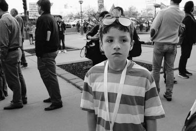 Boy looking away while standing in city