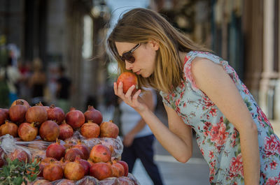 Full length of woman with fruits in background