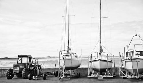 Boats moored at harbor against sky