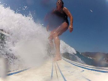 Full length of shirtless man jumping in water