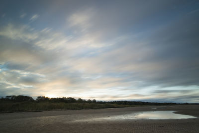 View of calm lake against cloudy sky