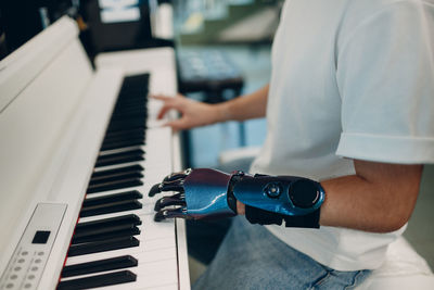 Midsection of man playing piano