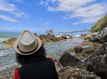 Rear view of woman looking at sea against sky