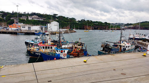 Fishing boats moored at harbor in city