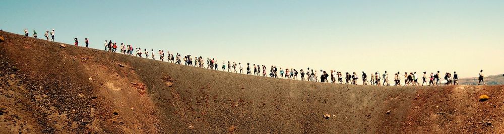 Large group of people walking on bare landscape