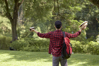Rear view of man standing by plants