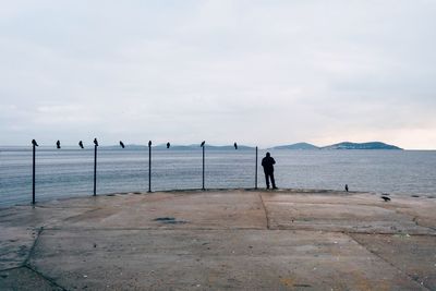 Man standing on beach against sky