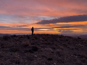 Silhouette man standing on mountain against sky during sunset